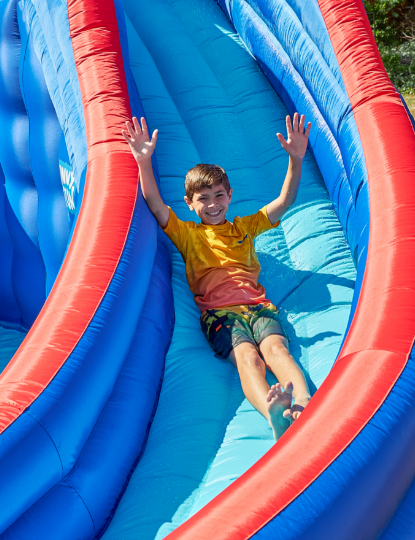 Kid Playing on Sunny & Fun Inflatable Kids Backyard Water Slide Park